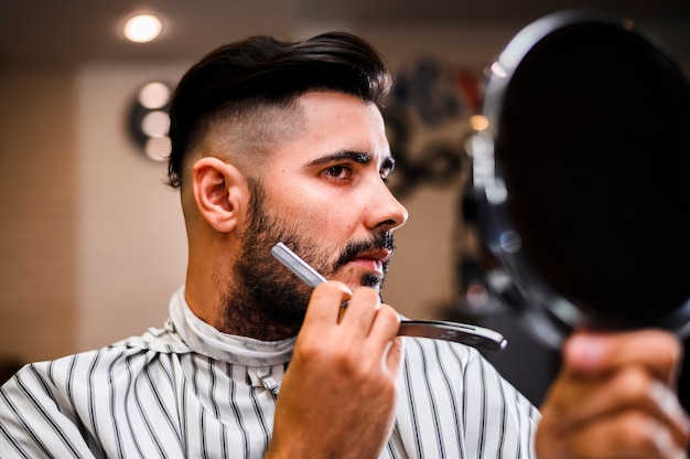 Free photo hair salon costumer looking in the mirror