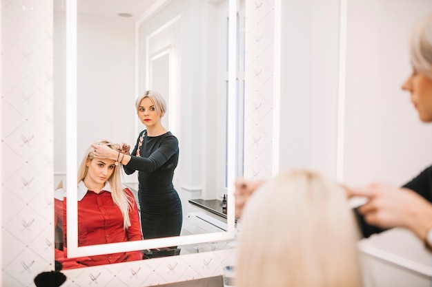 Hairdresser consulting client in salon