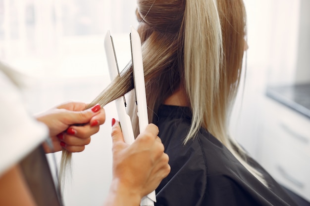 Free photo hairdresser does hairstyle for her client