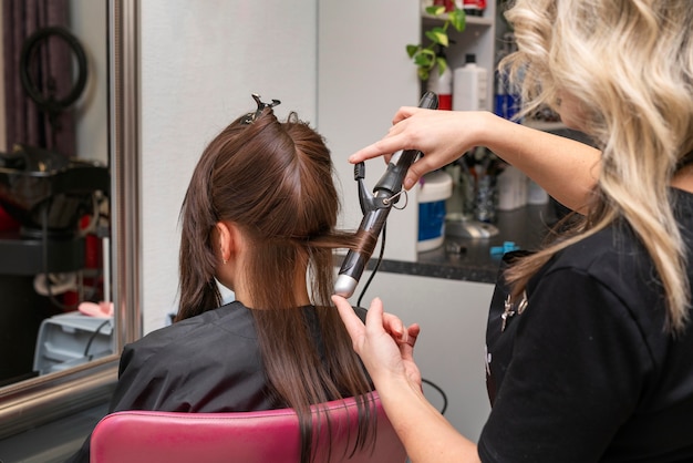 Free photo hairdresser taking care of a client's hair at the salon