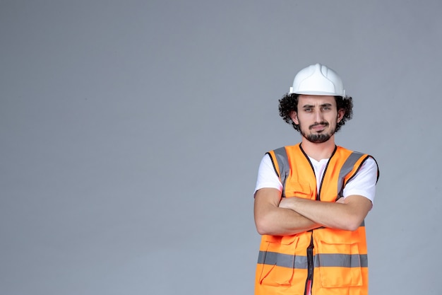 Half body shot of surprised male architect in warning vest with safety helmet over gray wave wall