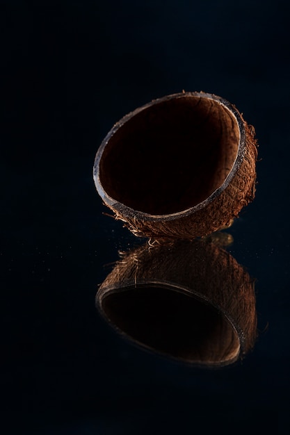 Free photo half of coconut over black surface