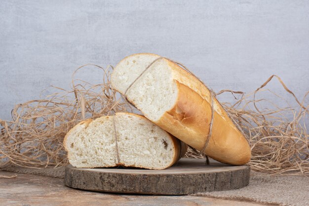 Half cut bread tied with rope on wooden piece