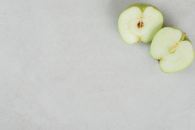 Half cut fresh apples on gray surface