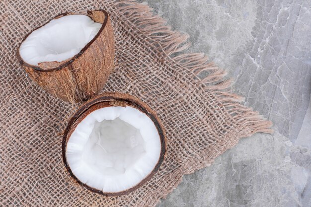 Half cut of fresh healthy coconut placed on stone surface.