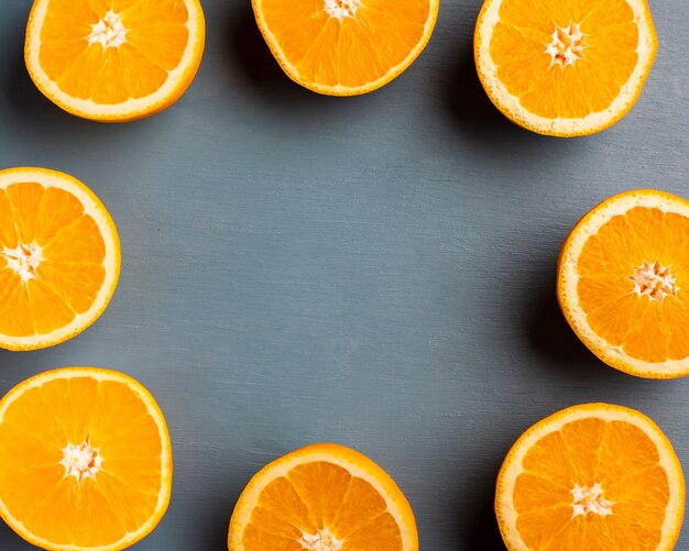 Half cut oranges forming frame on table