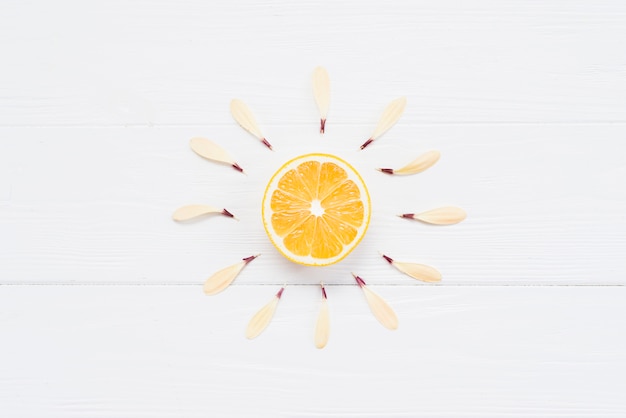 Free Photo half of lemon with petals on white background