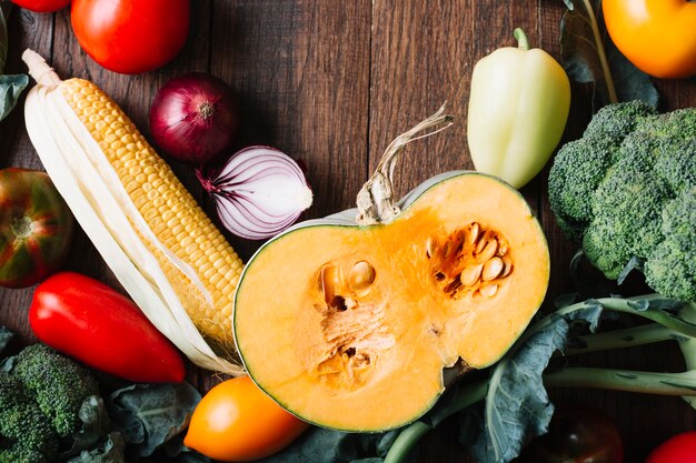 Half of pumpkin surrounded by veggies top view