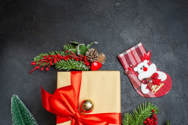 Half shot of Christmas mood with beautiful gifts with bow-shaped ribbon and fir branches decoration accessories xsmas sock on a dark background