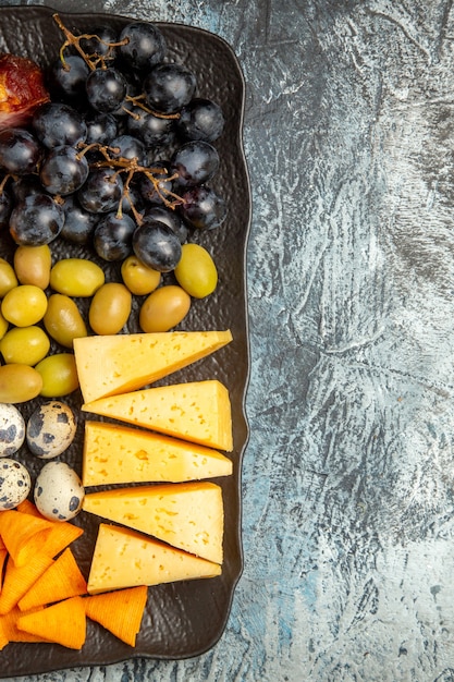 Free photo half shot of delicious best snack for wine served on brown tray on the right side on ice background