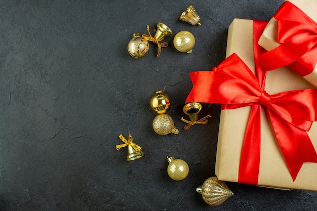 Half shot of gift box with red ribbon and decoration accessories on dark background