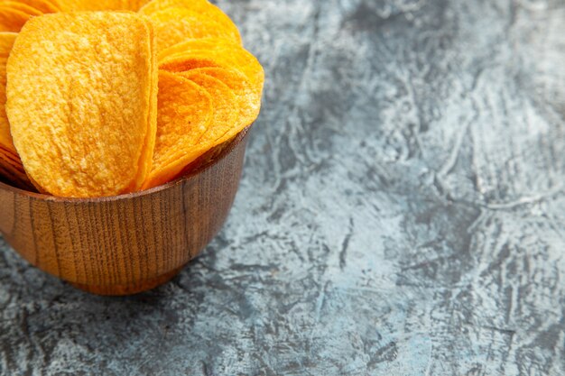 Half shot of homemade delicious crispy chips on gray table