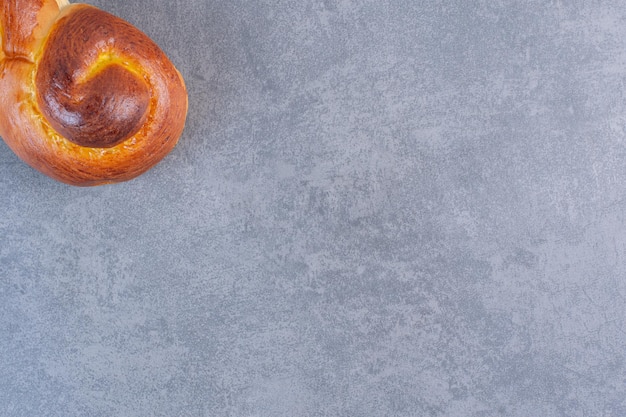 Half of a swirly sweet bun on marble background. High quality photo