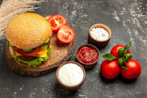 Free photo half-top view cheesy meat burger with seasonings on dark surface bun fries meat sandwich