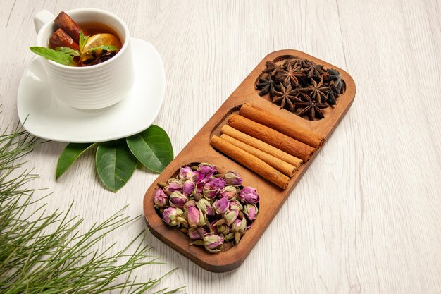 Half-top view cup of tea with cinnamon and flowers on white desk tea color flavor flower