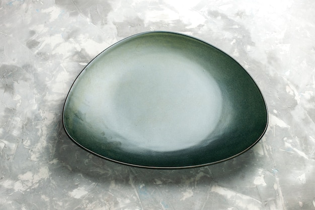 Half-top view empty green plate isolated on light-grey desk.