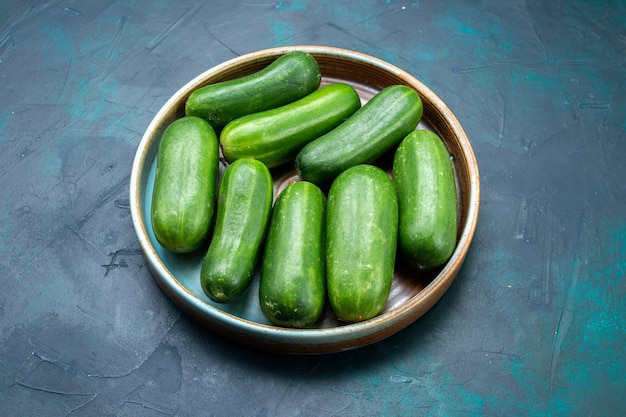 Free photo half-top view fresh green cucumbers ripe vegetables inside plate on dark-blue desk.