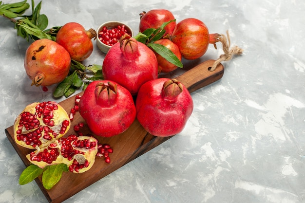 Half-top view fresh red pomegranates sour and mellow fruits on light white desk fruit fresh mellow ripe tree