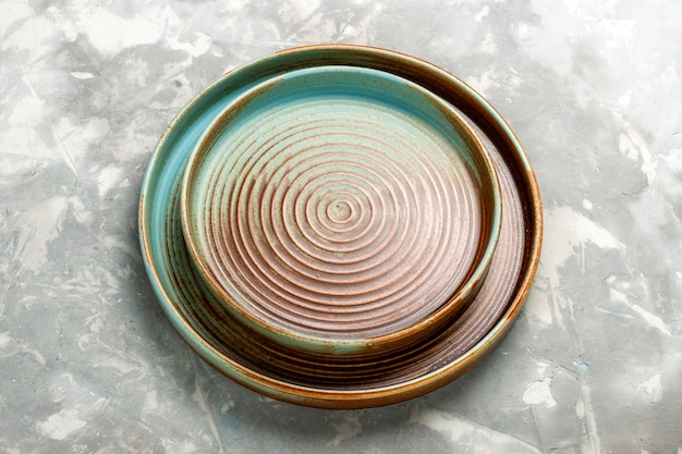 Half-top view round brown pan empty isolated on light-grey desk.