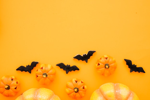 Halloween composition with bats, pumpkins and space on top