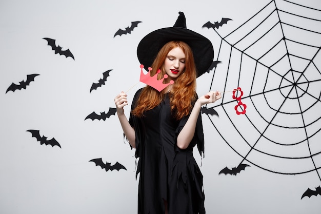 Free Photo halloween concept  beautiful girls in black witch dresses holding party props