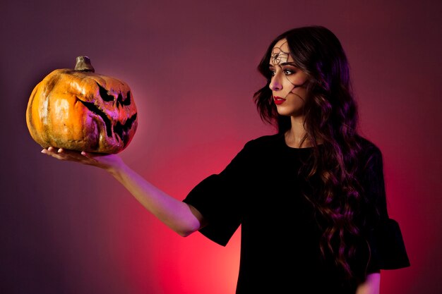 Halloween concept with girl looking at pumpkin