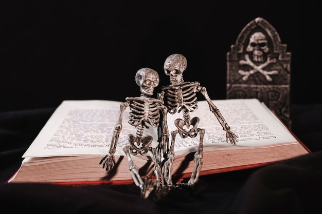 Free photo halloween concept with skeleton on book and tombstone