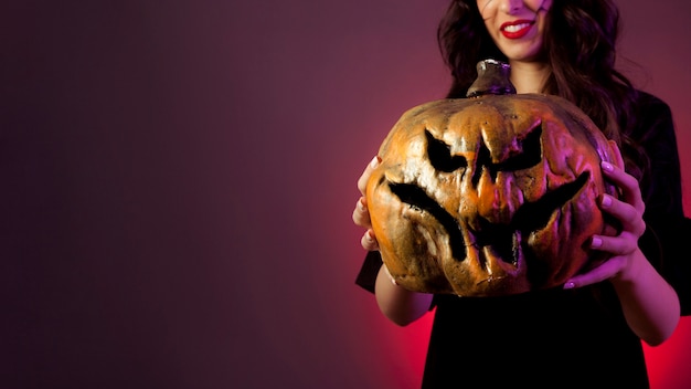 Free photo halloween concept with woman and pumpkin