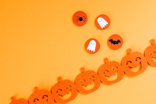 Free photo halloween decoration with a pumpkin garland on an orange background