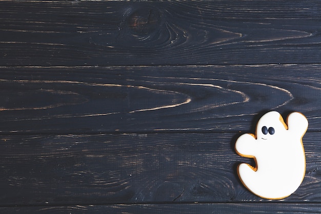 Halloween ghost cookie on black wooden table