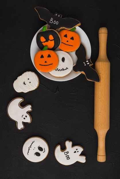 Halloween gingerbread on plate near biscuits and plunger