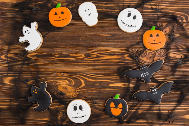 Halloween gingerbreads arranged in circle on wood background