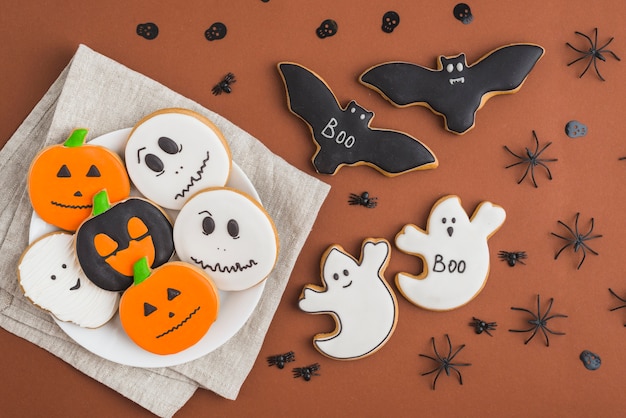 Free photo halloween gingerbreads on plate near bat and ghost cakes