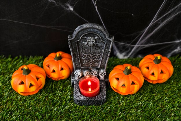 Halloween graveyard concept with pumpkins and candle