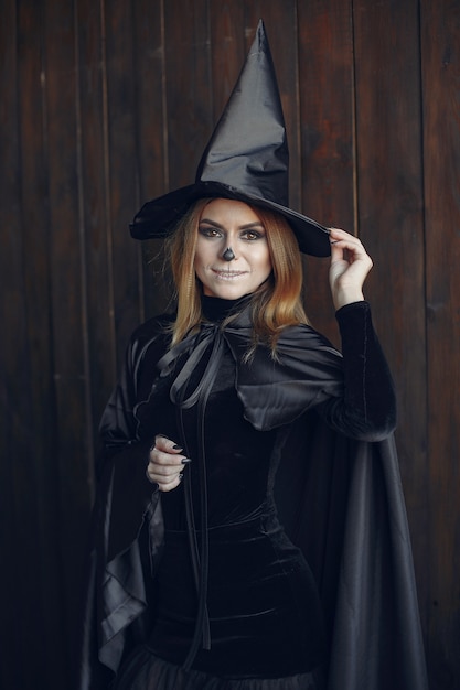 Free photo halloween make-up beautiful woman with blond hairstyle. model girl in black costume. halloween theme.