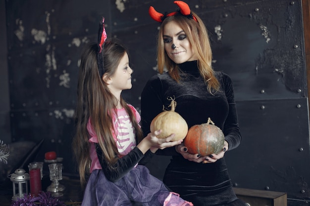 Halloween. Mother and daughter in halloween costume. Family at home.