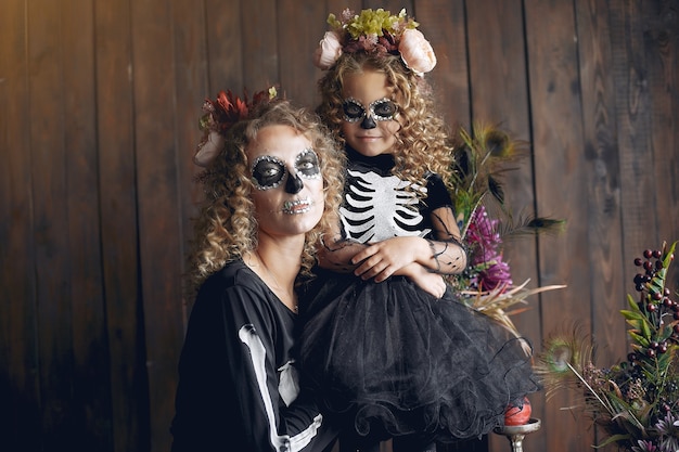 Halloween. Mother and daughter in Mexican style halloween costume. Family at home.