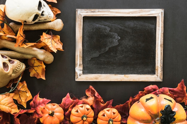 Free Photo halloween slate composition with autumn leaves and bones