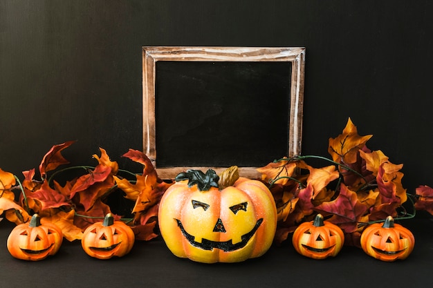 Halloween slate composition with autumn leaves and pumpkin