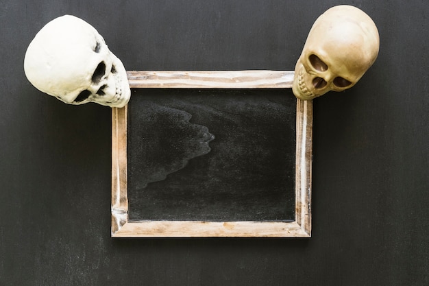 Free Photo halloween slate composition with two skulls