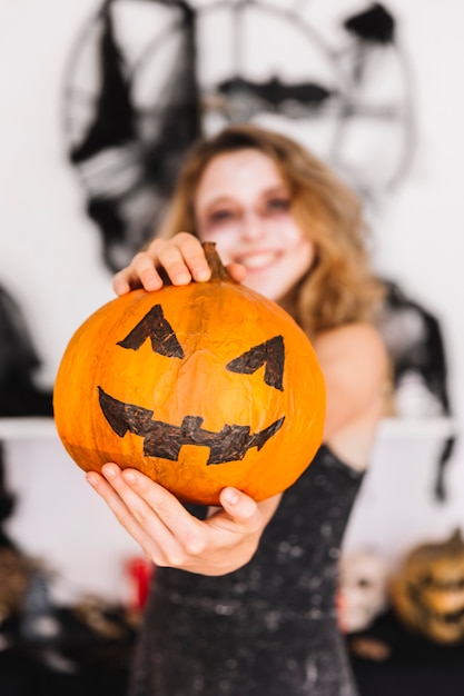 Free photo halloween teenage girl holding pumpkin