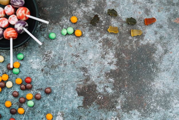 Halloween trick or treat sweets lying on grey surface