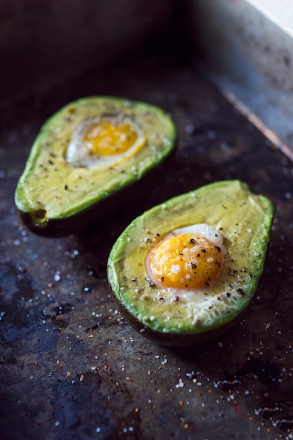 Free Photo halved avocado with egg yolk on kitchen worktop