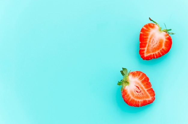 Halved juicy ripe strawberries with green stems