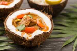 Free photo halves of coconut filled with stew close-up