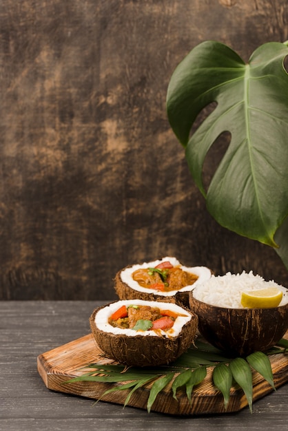 Halves of coconut filled with stew front view