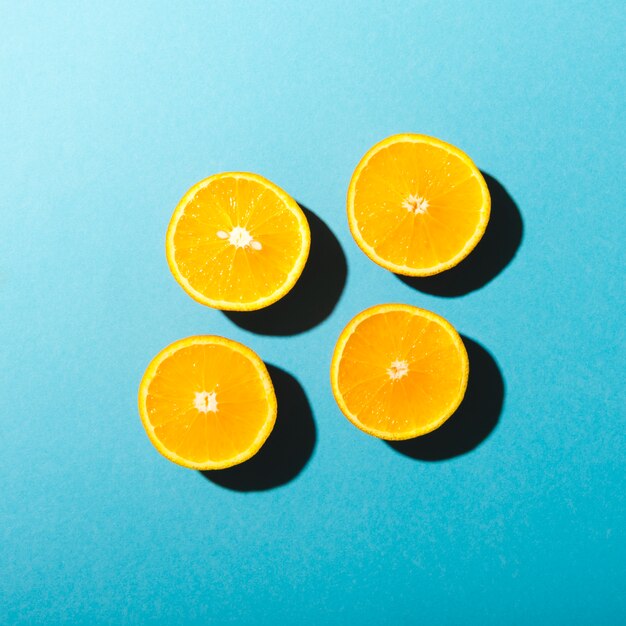 Halves of oranges on blue background