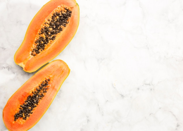 Free Photo halves of papaya fruit with copy space