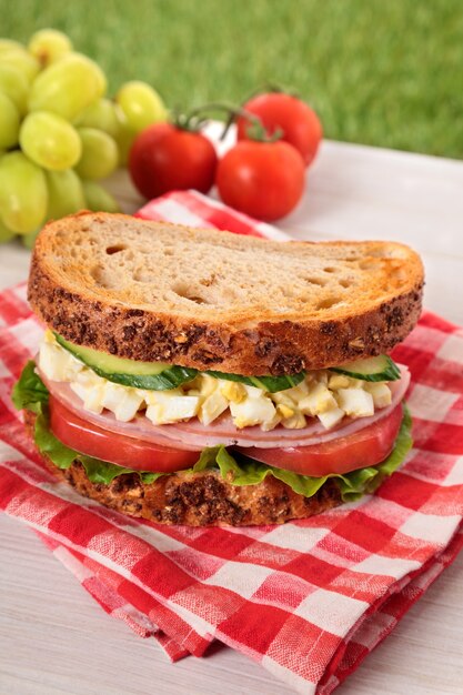 Ham and egg sandwich on picnic table