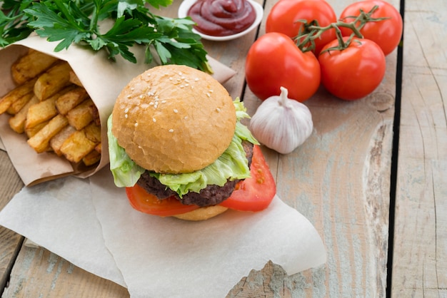 Free photo hamburger tasty french fries and tomatoes